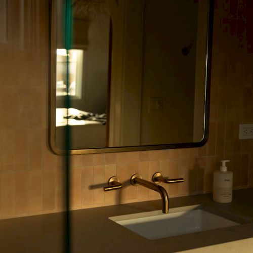 A dimly lit urban street scene outside a storefront at night, with a small bench and a glowing sign on the wall.